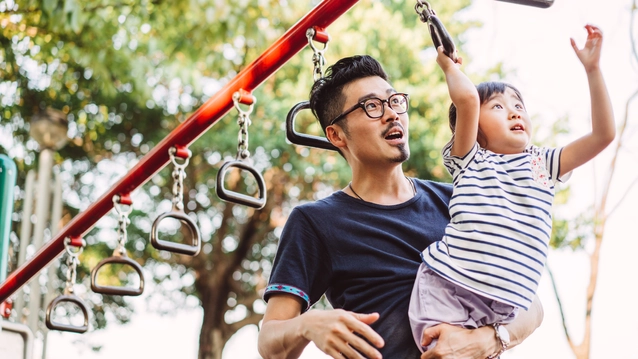 Young dad and little daughter doing exercise together in the sports ground joyfully
